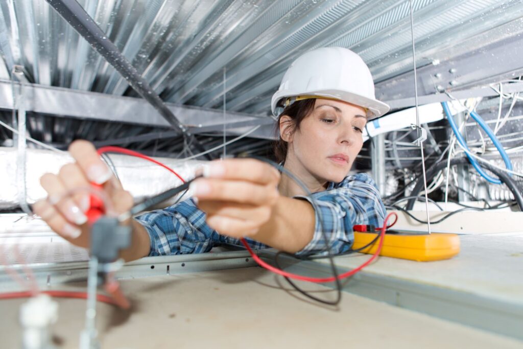 woman electrician checking wires