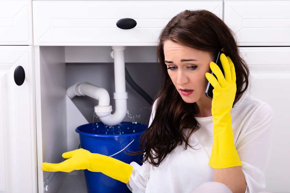 woman calling an emergency plumber