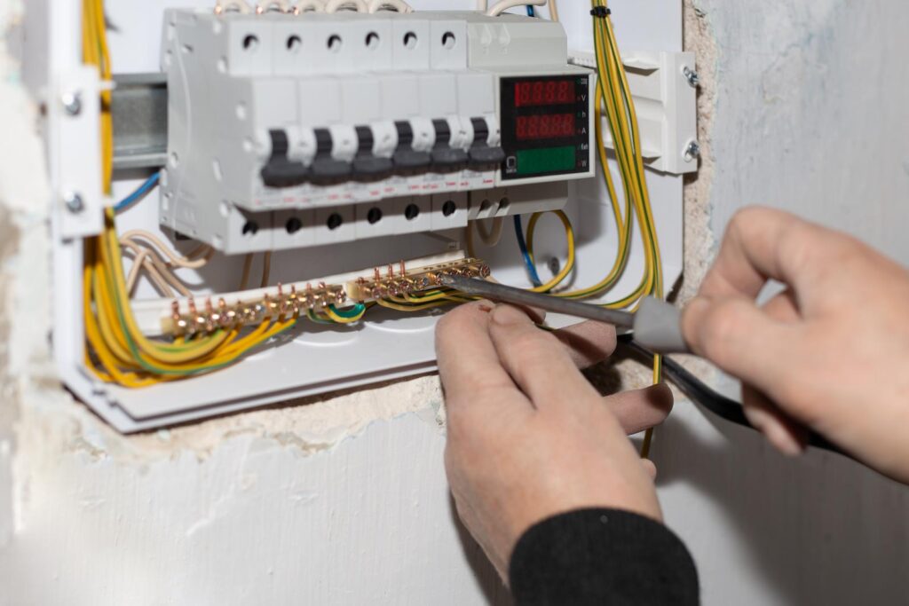 Electrical switchboard. A electrician installs a multifunctional shield to control electricity into the wall of the house.